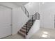 Modern staircase with sleek black railings and carpeted steps, adjacent to a bright, tiled entryway at 14189 Larkspur Lake Dr, Winter Garden, FL 34787