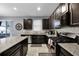 Well-equipped kitchen with dark cabinets, granite countertops, tile backsplash, and stainless appliances at 1003 Nathan Ridge Rd, Clermont, FL 34715