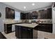 Modern kitchen with granite countertops, dark cabinets, stainless appliances, and tile backsplash at 1003 Nathan Ridge Rd, Clermont, FL 34715