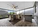 Screened outdoor kitchen boasts stainless grill, mini-fridge, and custom bar, perfect for entertaining at 1003 Nathan Ridge Rd, Clermont, FL 34715
