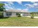 Charming single story home with a two car garage, neutral paint, and green lawn at 10453 Old Studio Rd, Clermont, FL 34711