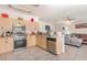 Kitchen with stainless steel appliances, wood cabinets, and tile flooring adjacent to the living area at 10453 Old Studio Rd, Clermont, FL 34711