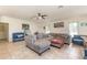 A spacious living room features tile floors, vaulted ceilings, and modern furniture at 10453 Old Studio Rd, Clermont, FL 34711