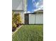Backyard featuring well-maintained lawn, tropical plants, and access to enclosed patio at 11714 Peachstone Ln, Orlando, FL 32821