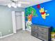Bright bedroom showcasing unique Winnie the Pooh themed wall art and a spacious closet at 11714 Peachstone Ln, Orlando, FL 32821