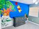Charming bedroom featuring whimsical Winnie the Pooh themed wall art and a stylish gray dresser at 11714 Peachstone Ln, Orlando, FL 32821