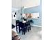 View of dining area showcasing a black table set, chandelier, and an open breakfast bar connecting to the kitchen at 11714 Peachstone Ln, Orlando, FL 32821