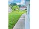 Well-maintained front yard featuring a young tree, green lawn and walkway leading to the house at 11714 Peachstone Ln, Orlando, FL 32821