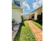 Charming side yard with a brick path leading to a white gate, accented with vibrant greenery at 11714 Peachstone Ln, Orlando, FL 32821