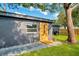 Modern home exterior featuring an outdoor shower, stepping stones, and lush green grass at 1201 Manchester Rd, Maitland, FL 32751