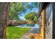 A view of the home's backyard featuring a pool, lawn, trees, and a wood fence at 1201 Manchester Rd, Maitland, FL 32751