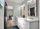 Bright bathroom featuring double vanity with gold fixtures, marble counters, and view to the primary bedroom at 1201 Manchester Rd, Maitland, FL 32751