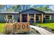 Charming home featuring a decorative wooden address sign, black trim and stylish craftsman columns at 1201 Manchester Rd, Maitland, FL 32751
