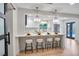 Modern kitchen bar with white countertops, stylish pendant lights and seating for four at 1201 Manchester Rd, Maitland, FL 32751