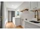 Laundry room with white cabinets, sink, wood shelf, and dark gray sliding door at 1201 Manchester Rd, Maitland, FL 32751