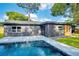 A beautiful in-ground pool surrounded by a well maintained green lawn and a modern house at 1201 Manchester Rd, Maitland, FL 32751