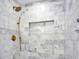 Walk-in shower featuring white marble tile, brass fixtures and convenient toiletry niche at 1201 Manchester Rd, Maitland, FL 32751