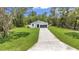 Overhead view of a cozy home with a long driveway surrounded by lush greenery at 13101 Sw 85 Pl, Dunnellon, FL 34432