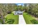 New home with manicured lawn, long driveway, and dark garage door, as seen from above at 13101 Sw 85 Pl, Dunnellon, FL 34432