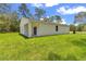 Back exterior view of the home showing the covered patio and ample green space at 13101 Sw 85 Pl, Dunnellon, FL 34432