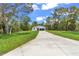 Inviting single-story home featuring a long driveway and lush green lawn at 13101 Sw 85 Pl, Dunnellon, FL 34432