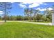 Expansive front yard view, enhanced by its lush green grass, leading to a long driveway at 13101 Sw 85 Pl, Dunnellon, FL 34432