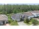 Aerial view of a well-manicured home with a gray roof, lush landscaping, and a brick driveway at 13137 Lower Harden Ave, Orlando, FL 32827