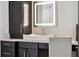Close up of modern bathroom featuring dark wood cabinets and drawers, sleek countertop, and lit mirror at 13137 Lower Harden Ave, Orlando, FL 32827