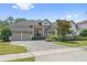 Beautiful home with a lush green lawn and landscaping in front of a three car garage at 13137 Lower Harden Ave, Orlando, FL 32827