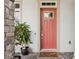 Inviting home entrance features a stylish red front door, stone accents, and potted plant at 13137 Lower Harden Ave, Orlando, FL 32827