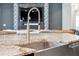 Close-up of a modern kitchen sink and countertop with a stylish faucet and backsplash design at 13137 Lower Harden Ave, Orlando, FL 32827