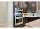 This kitchen features stainless steel ovens and dark cabinets that provide a modern and sleek design at 13137 Lower Harden Ave, Orlando, FL 32827