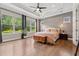 Spacious main bedroom with tray ceiling, wood floors, and large windows overlooking lush landscaping at 13137 Lower Harden Ave, Orlando, FL 32827