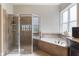Bright bathroom featuring a glass-enclosed shower, soaking tub, and a window for natural light at 14285 United Colonies Dr, Winter Garden, FL 34787