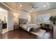 The main bedroom features a tray ceiling, decorative accent wall, wood floors and access to the ensuite bathroom at 14285 United Colonies Dr, Winter Garden, FL 34787