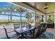 Covered outdoor dining area featuring a large table with seating and tranquil views of the pool and lake at 14285 United Colonies Dr, Winter Garden, FL 34787