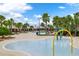 Community pool area with palm trees, lounge chairs, and a splash pad for children at 14285 United Colonies Dr, Winter Garden, FL 34787