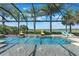 Stunning screened pool featuring dual fire bowls and a view of the lake, perfect for relaxation and entertainment at 14285 United Colonies Dr, Winter Garden, FL 34787