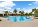 Large community swimming pool surrounded by palm trees and lounge chairs offers a resort-like experience at 14285 United Colonies Dr, Winter Garden, FL 34787
