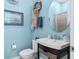 Charming powder room with blue walls, decorative mirror, and stylish vanity at 14639 Winter Stay Dr, Winter Garden, FL 34787