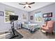 Comfortable bedroom with large windows, a ceiling fan, and a cozy armchair at 14639 Winter Stay Dr, Winter Garden, FL 34787