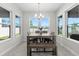 Bright dining area with large windows, stylish chandelier, and wooden table with bench seating at 14639 Winter Stay Dr, Winter Garden, FL 34787