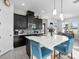Stylish kitchen featuring dark cabinets, a large island with bar seating, and stainless steel appliances at 14639 Winter Stay Dr, Winter Garden, FL 34787