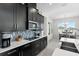Modern kitchen featuring dark cabinetry, sleek countertops, stainless appliances, and an adjacent dining area at 14639 Winter Stay Dr, Winter Garden, FL 34787