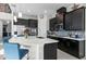 Bright kitchen boasts stainless appliances, dark cabinetry, an island with seating, and tile backsplash at 14639 Winter Stay Dr, Winter Garden, FL 34787