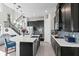 Open kitchen features dark cabinetry, an island with seating, stainless appliances, and nearby stairway at 14639 Winter Stay Dr, Winter Garden, FL 34787