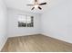 Bright bedroom featuring wood-look floors, ceiling fan, and a window with blinds at 14706 Driftwater Dr, Winter Garden, FL 34787