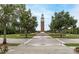 Scenic clock tower view with green lawns, walkways, and trees, offering a serene community gathering spot at 14706 Driftwater Dr, Winter Garden, FL 34787