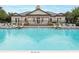 Large community pool surrounded by lounge chairs and umbrellas, perfect for relaxation and socializing at 14706 Driftwater Dr, Winter Garden, FL 34787