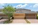 Property showcasing three garages and a brick driveway with landscaped curb appeal and a lush green tree at 14706 Driftwater Dr, Winter Garden, FL 34787